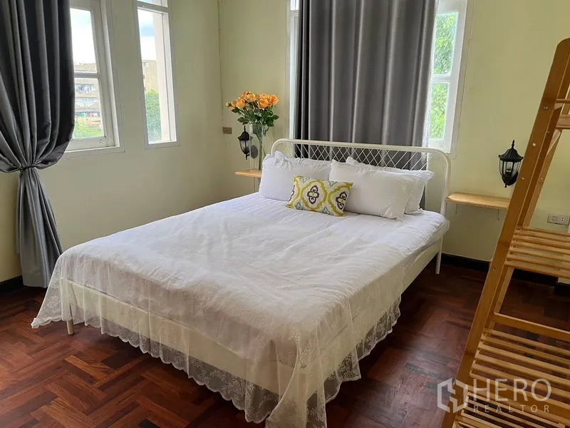 Home Office for rent in Suan Luang, Bangkok - Sunlit bedroom with bed, wooden rack and multiple windows.