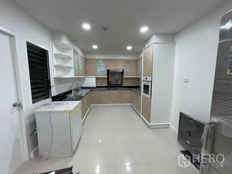 คอนโด ให้เช่าในKhlong Toei, Bangkok - ครัวแยกสไตล์ยู ตู้ไม้โทนอ่อน ท็อปหินสีดำ พร้อมเตาอบบิวท์อิน