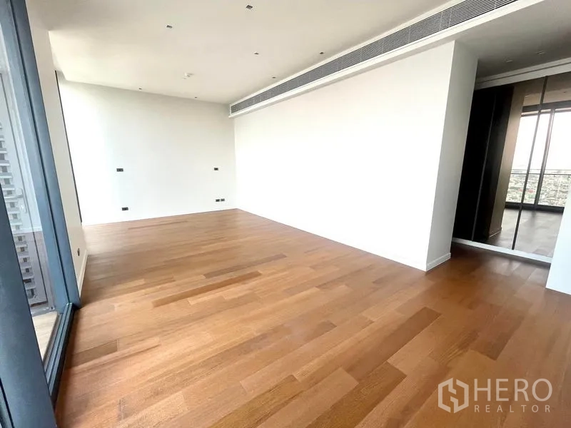 Condominium for rent or sale in Bangkok - Spacious bedroom with wide wooden flooring and sliding door to the balcony.