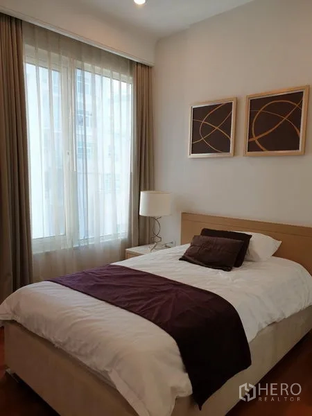 Condominium for rent in Pathum Wan, Bangkok - Bright secondary bedroom with single bed, artwork and floor-to-ceiling window.