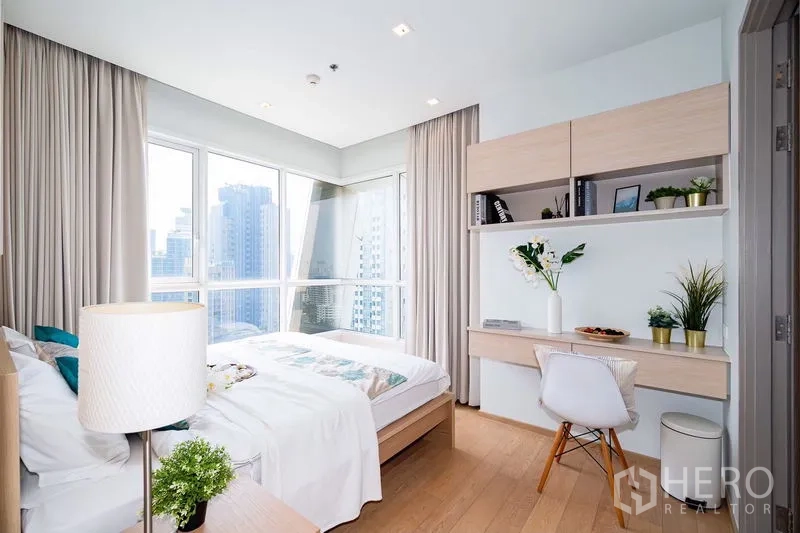 公寓 出租在Watthana, Bangkok - 转角卧室，带书桌、壁柜与环景窗。