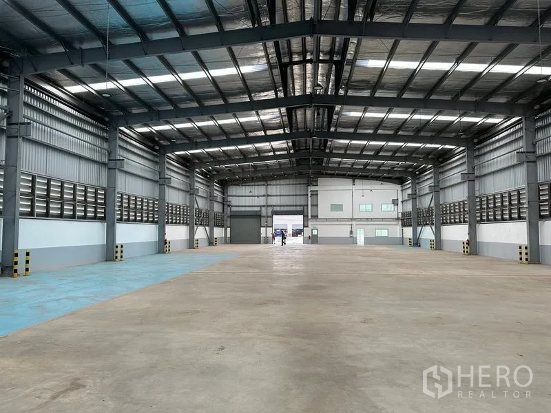 โรงงาน ให้เช่าในMueang Samut Prakan, Samut Prakan - มุมมองภายในโกดังหันไปยังอาคารสำนักงานท้ายอาคาร พร้อมประตูม้วนสองจุด