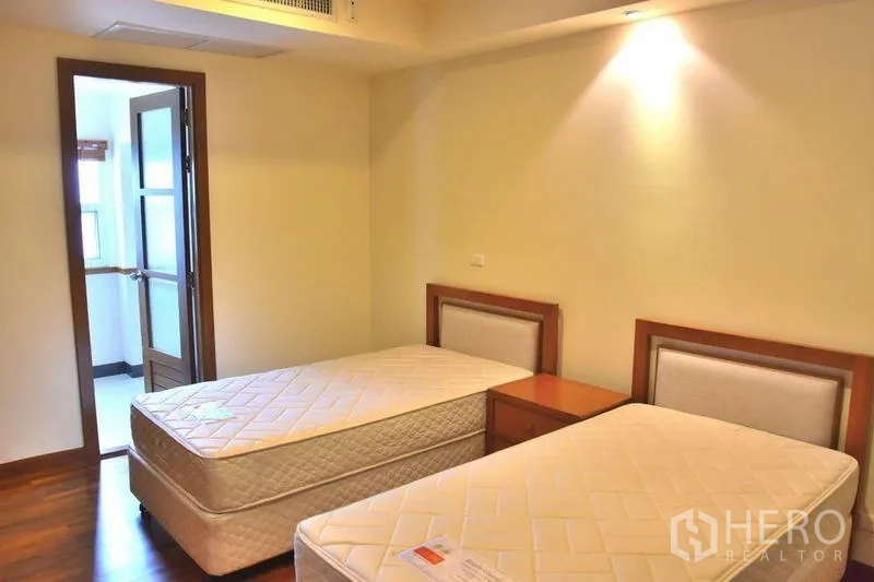 房间 出租在Sathon, Bangkok - 次卧配两张单人床，灯光温馨。