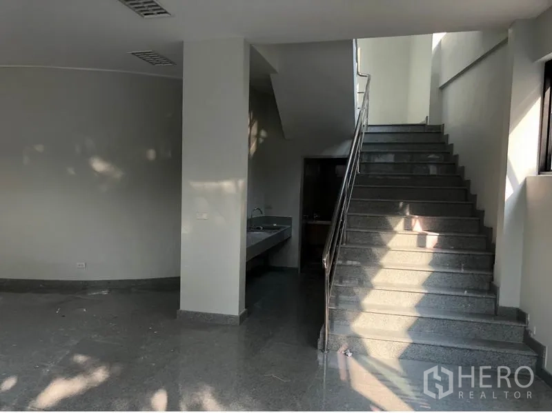 办公空间 出租在Khlong Toei, Bangkok - 室内楼梯配不锈钢扶手，旁有洗手台与卫生间区域。