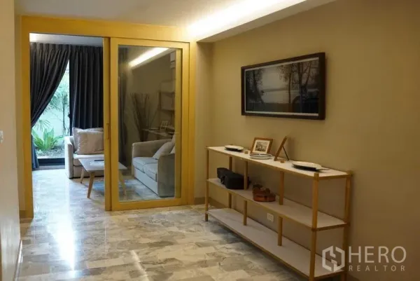 คอนโด ให้เช่าในWatthana, Bangkok - โถงทางเข้าพร้อมชั้นวางของและประตูกระจกเปิดสู่ห้องนั่งเล่นวิวสวน