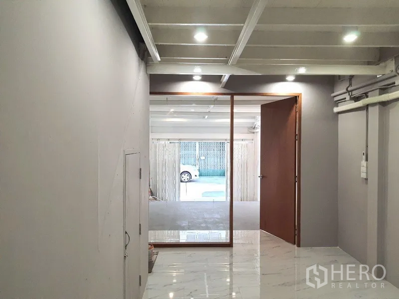 อาคารพาณิชย์ ให้เช่าในPhra Khanong, Bangkok - มุมมองจากห้องด้านในผ่านผนังกระจกไปยังพื้นที่จอดรถหน้าอาคารและถนน