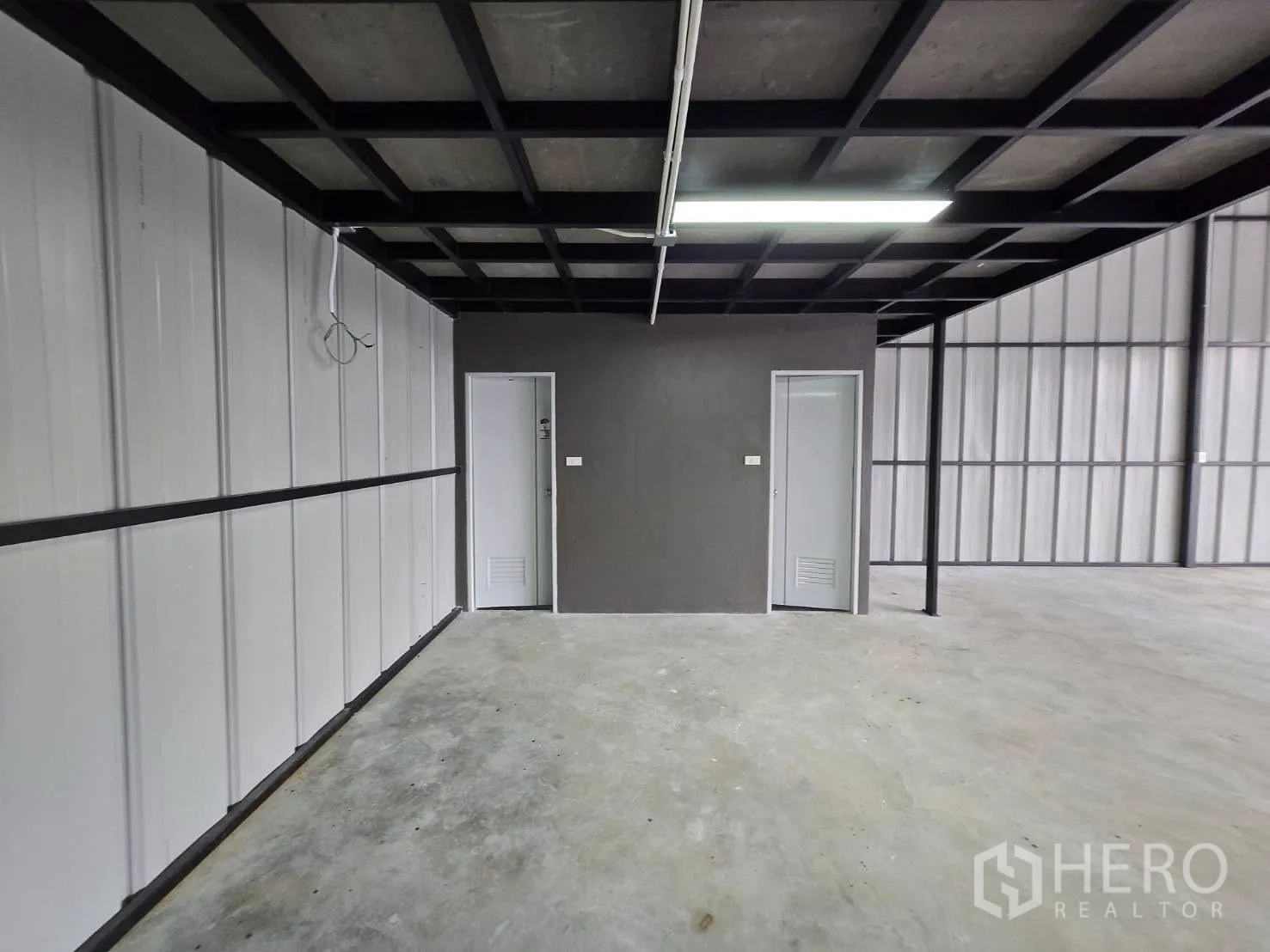 Warehouse for rent - Service wall under the mezzanine with two doors, power points and linear lighting.