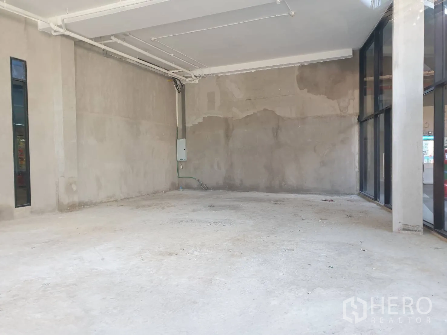 零售空间 出租在Watthana, Bangkok - 未装修零售铺面，层高充裕，水泥地面与落地玻璃门面。