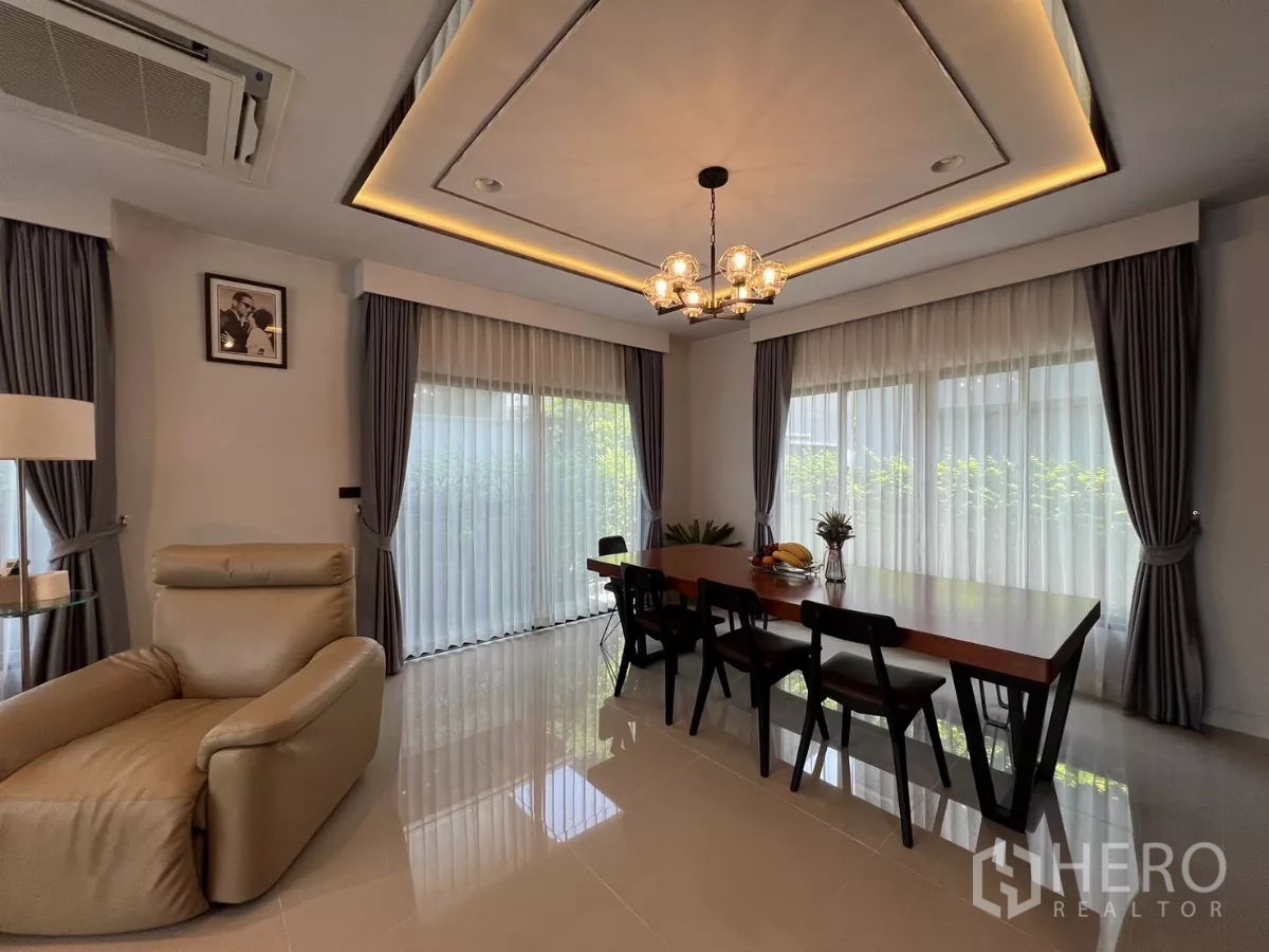 Detached House for rent or sale in Bang Kapi, Bangkok - Corner dining room with pendant lights and wraparound sheer curtains.