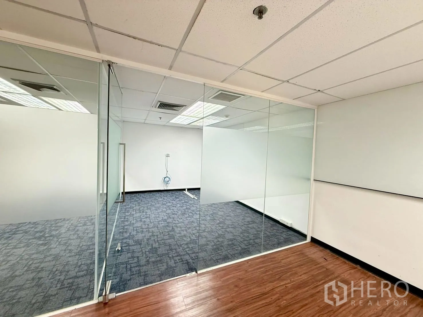 ออฟฟิศ for rent in Watthana, Bangkok - ห้องประชุมกั้นผนังกระจกติดฟิล์มฝ้า ปูพรม ถัดจากพื้นลายไม้.