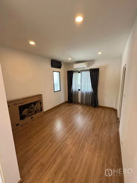 Detached House for rent in Don Mueang, Bangkok - Secondary bedroom with wood floors, window, blackout curtains, air conditioners and space for TV.