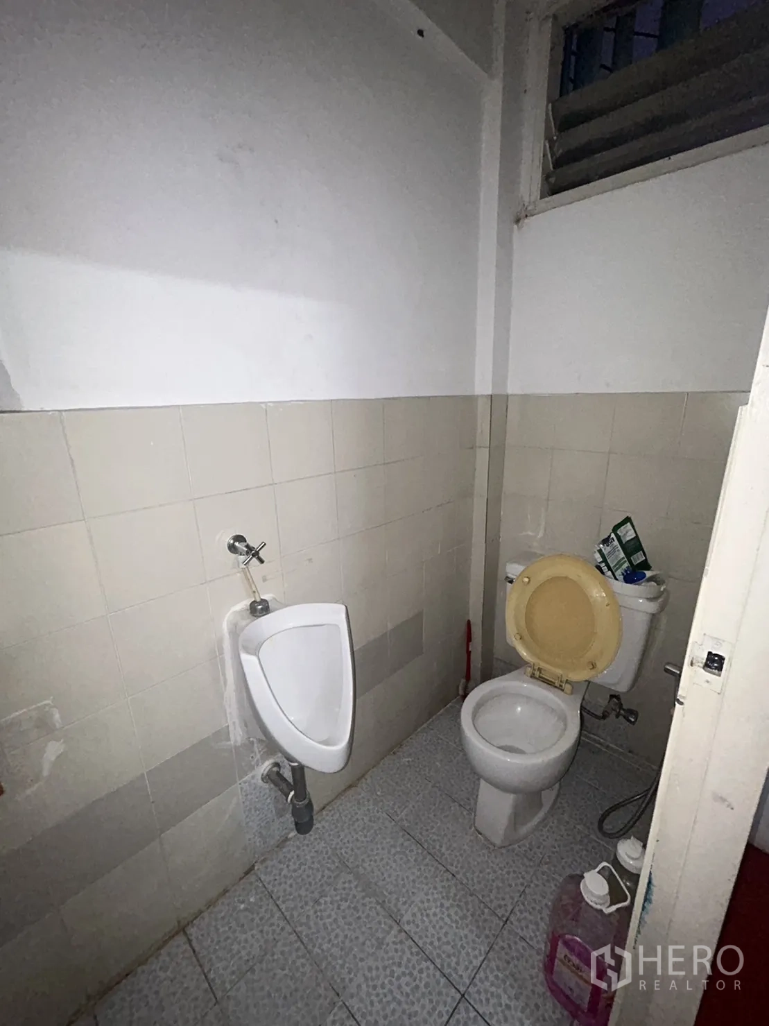 อาคารพาณิชย์ ให้เช่าในKhlong Toei, Bangkok - ห้องน้ำเก่าพร้อมโถปัสสาวะและชักโครกบนพื้นกระเบื้อง