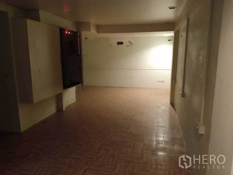 零售空间 出租在Watthana, Bangkok - 后场区域，地砖与配电柜，适合储物或后台办公。