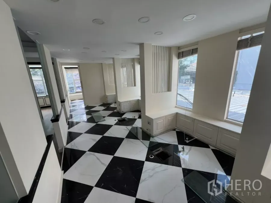 พื้นที่ขายปลีก ให้เช่า - พื้นที่ภายในสว่าง พื้นกระเบื้องลายตารางขาวดำ และหน้าต่างบานใหญ่