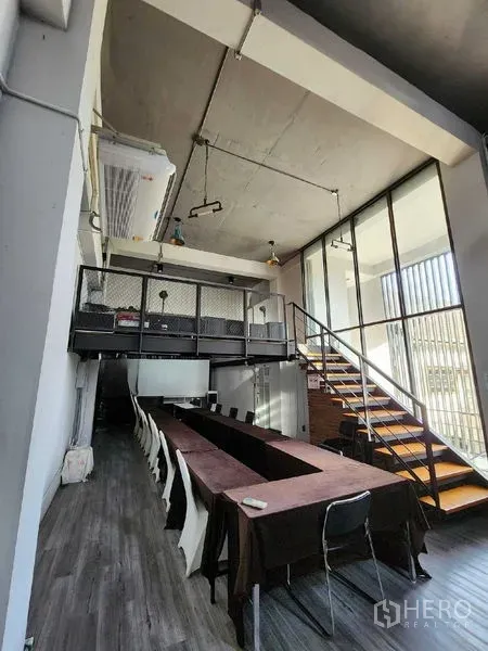 Home Office for rent in Mueang Nonthaburi, Nonthaburi - Long training or conference room with a mezzanine platform and a glass-walled staircase.