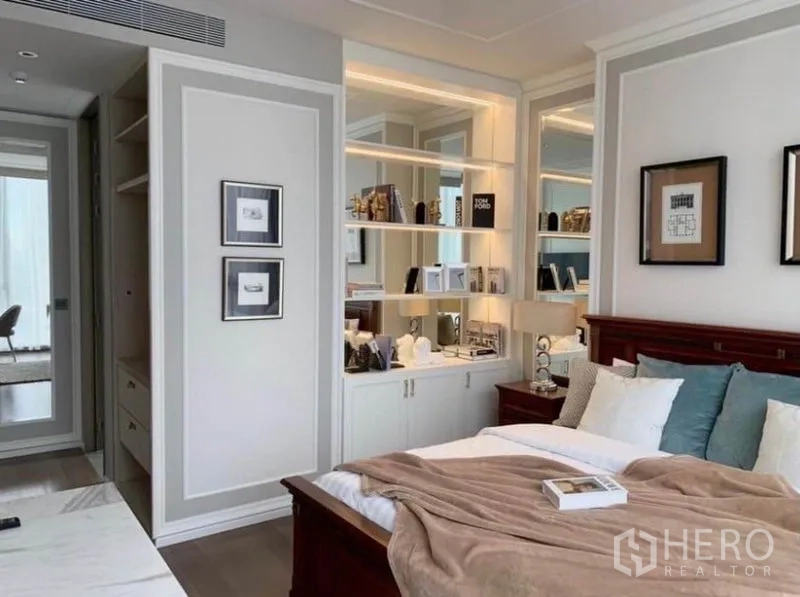 คอนโด ให้เช่าในKhlong Toei, Bangkok - มุมห้องนอนที่มีชั้นวางแบบบิลท์อิน ตู้เก็บของ และไฟสว่างนุ่มนวลข้างเตียง