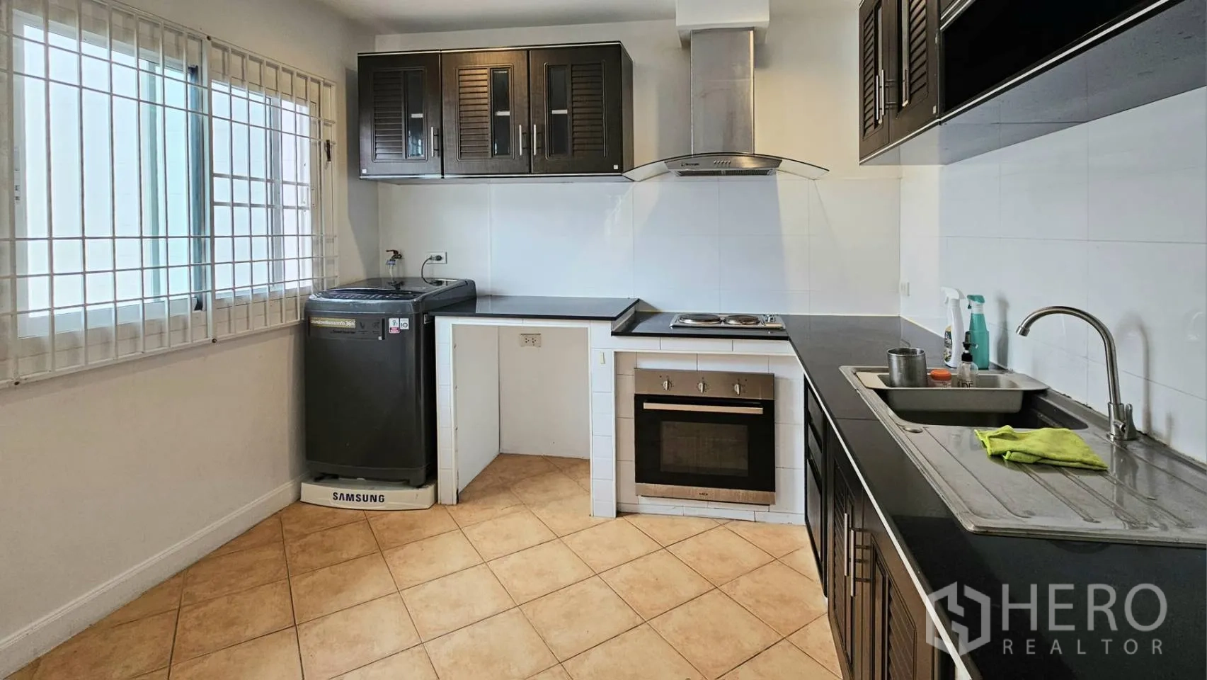 Detached House for rent in Saphan Sung, Bangkok - Fitted kitchen with oven, cooktop, range hood, and washing machine.