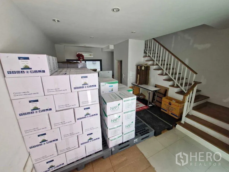 联排别墅 出售在Phra Pradaeng, Samut Prakan - 开放式一层空间，楼梯与堆放的箱子，可作客厅或办公室