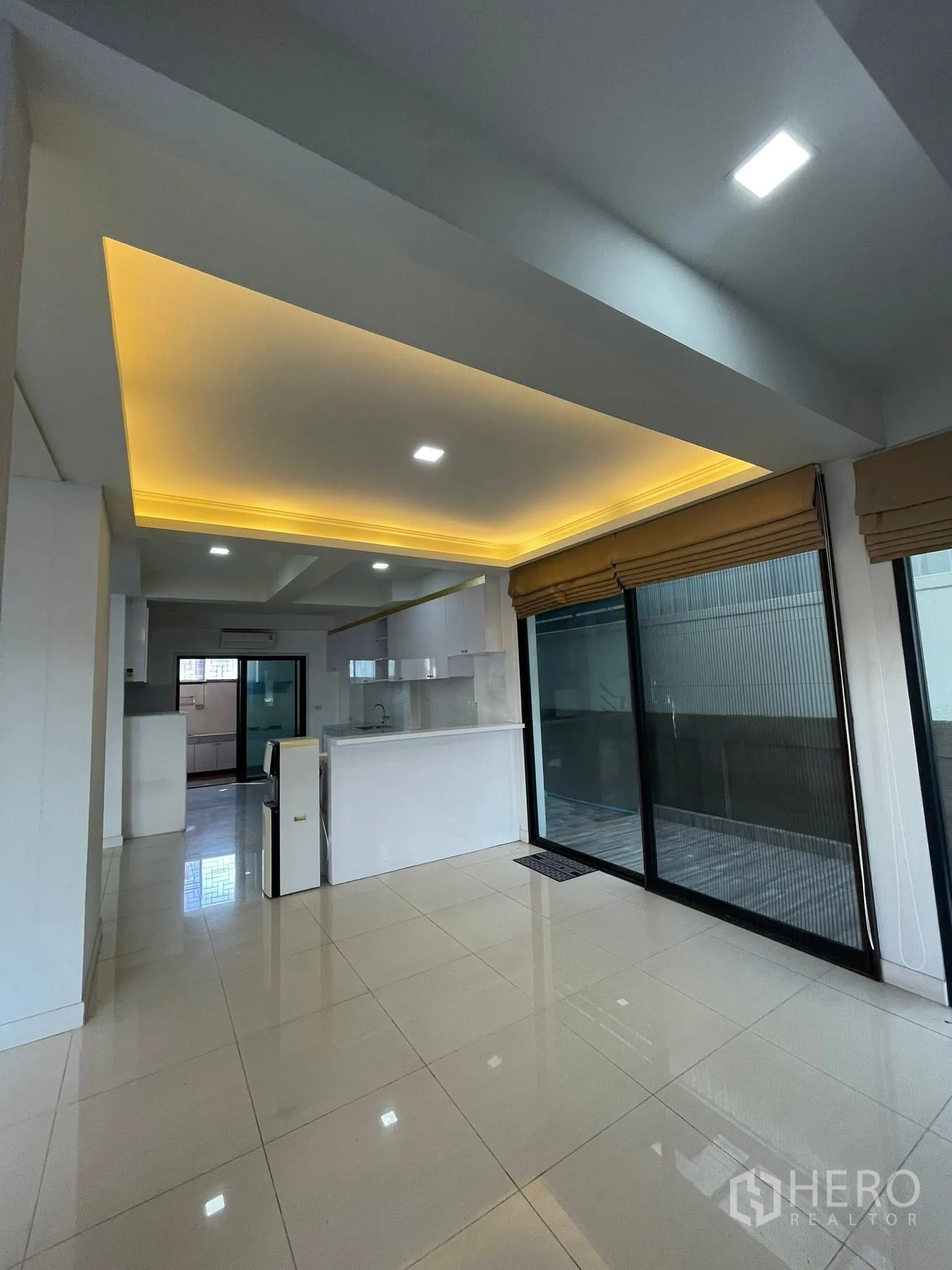 Detached House for rent or sale in Lam Luk Ka, Pathum Thani - Living area with cove lighting ceiling and large sliding glass doors to the terrace.