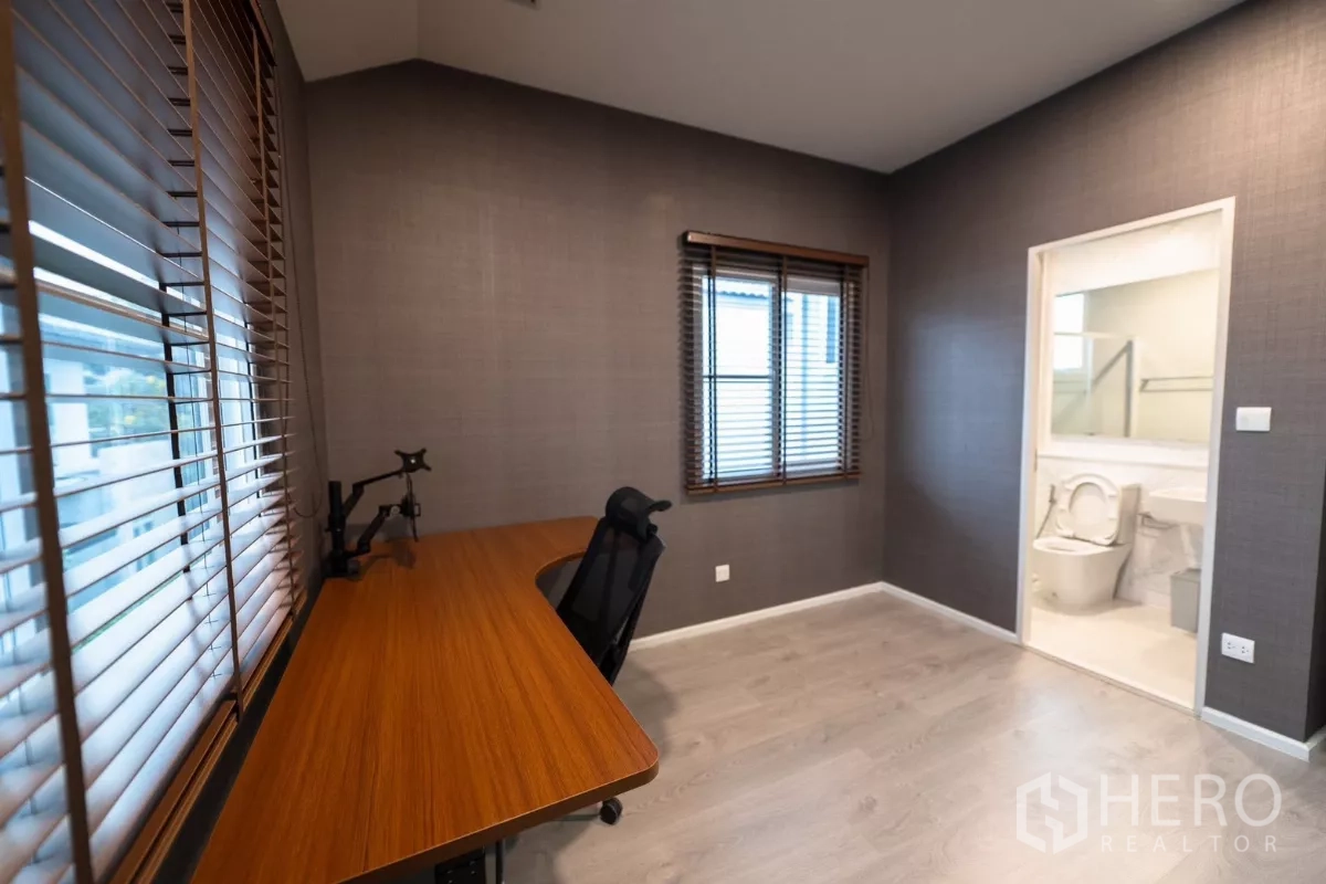 Detached House for rent or sale in Prawet, Bangkok - Large secondary bedroom with desk and floor-to-ceiling curtains.