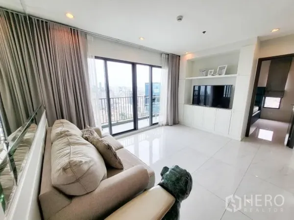 คอนโด ขายในWatthana, Bangkok - พื้นที่นั่งเล่นมีผนังกระจกเงา ประตูออกระเบียง และชั้นวางทีวีบิวท์อิน