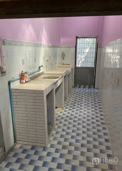 Warehouse for rent in Sai Noi, Nonthaburi - Utility wash area with multiple concrete sinks and blue checkered floor tiles.