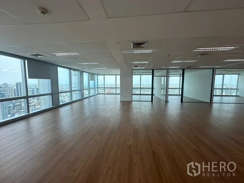Office Space for rent - Spacious office interior featuring floor-to-ceiling windows, wood floors and separate glass offices.