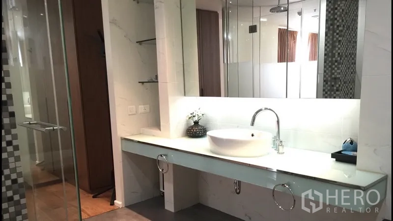 公寓 出租在Bang Rak, Bangkok - 卫浴梳洗台配台上盆与大镜面，玻璃淋浴间相连。