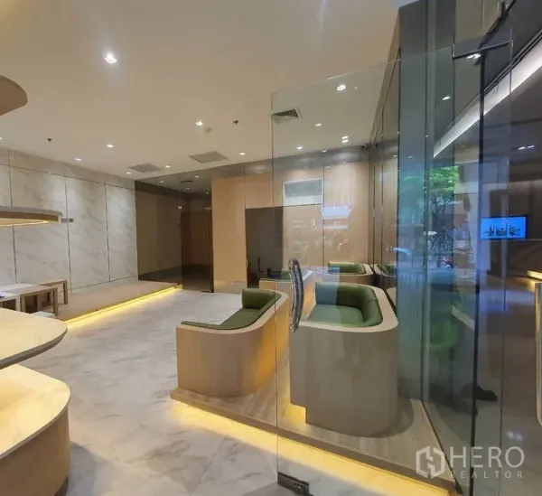 零售空间 出租在Bang Rak, Bangkok - 精装店铺一隅，内置绿色卡座、玻璃入口与暖色灯光。