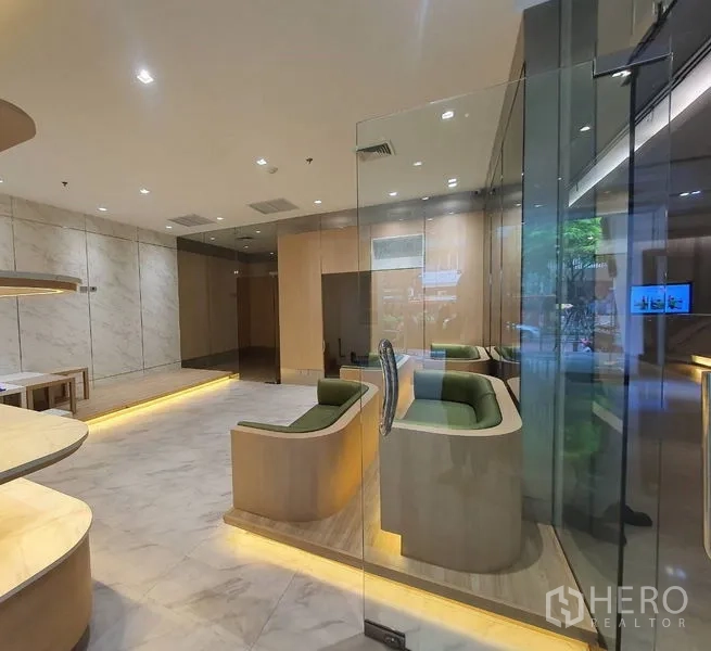 零售空间 出租在Bang Rak, Bangkok - 精装店铺一隅，内置绿色卡座、玻璃入口与暖色灯光。