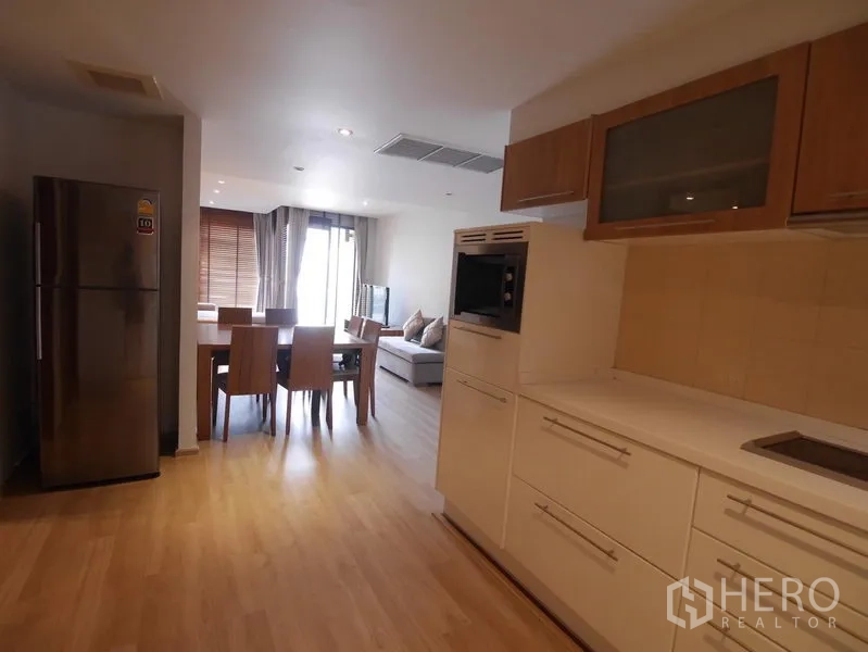 คอนโด ให้เช่าในPathum Wan, Bangkok - ครัวเปิดเชื่อมต่อพื้นที่ทานอาหารและห้องนั่งเล่นสว่าง พร้อมทางออกสู่ระเบียง