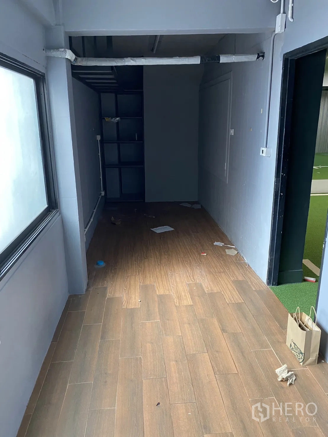 พื้นที่ขายปลีก ให้เช่าในPhaya Thai, Bangkok - ห้องออฟฟิศหรือเก็บของทรงยาว พื้นลายไม้ มีชั้นวางและหน้าต่างรับแสง.