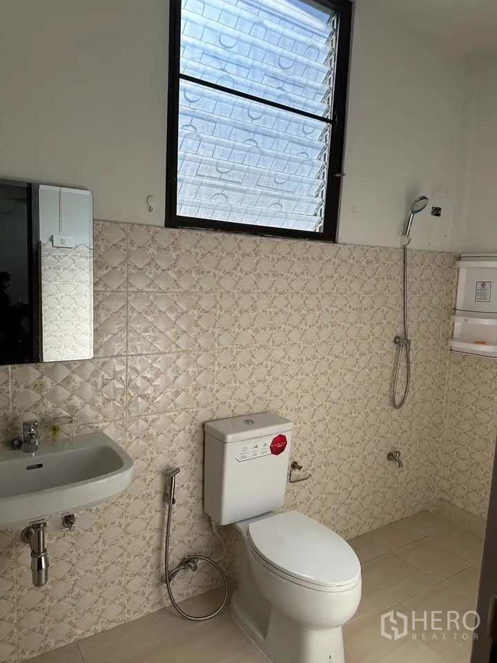 独栋房屋 for rent in Phra Khanong, Bangkok - 明亮浴室，米色花纹瓷砖、窗户、淋浴、马桶和洗手盆。