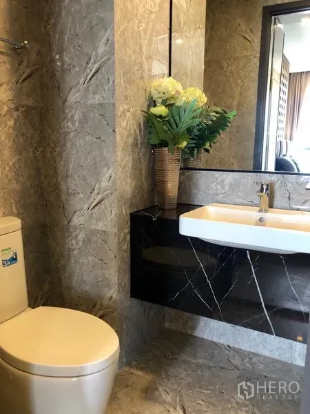 คอนโด ให้เช่าในWatthana, Bangkok - ห้องน้ำตกแต่งหินอ่อนพร้อมอ่างล้างหน้า กระจกบานใหญ่ และโถสุขภัณฑ์