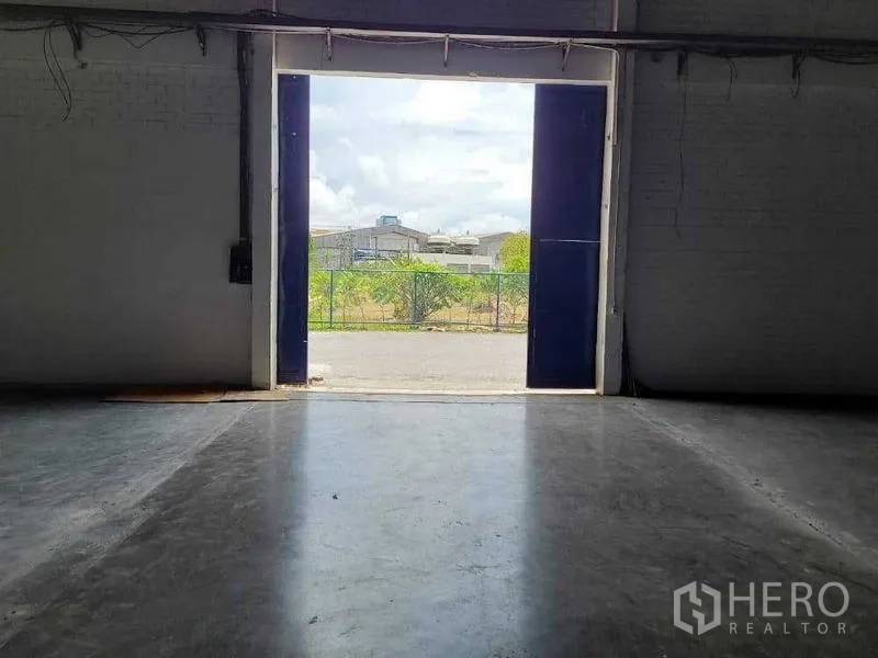 Warehouse for rent in Phra Khanong, Bangkok - Large loading door opening to the driveway and fenced yard outside