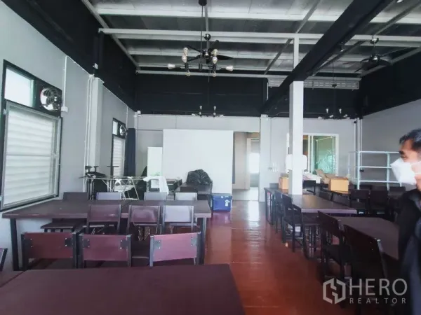 Retail Space for rent in Khlong Toei, Bangkok - Spacious back room with high ceiling, multiple tables, and flexible layout.