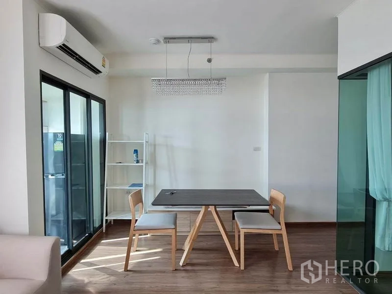 公寓 出租或出售在Yan Nawa, Bangkok - 采光良好的用餐角，双人餐桌、水晶吊灯，旁连推拉玻璃门与厨房。