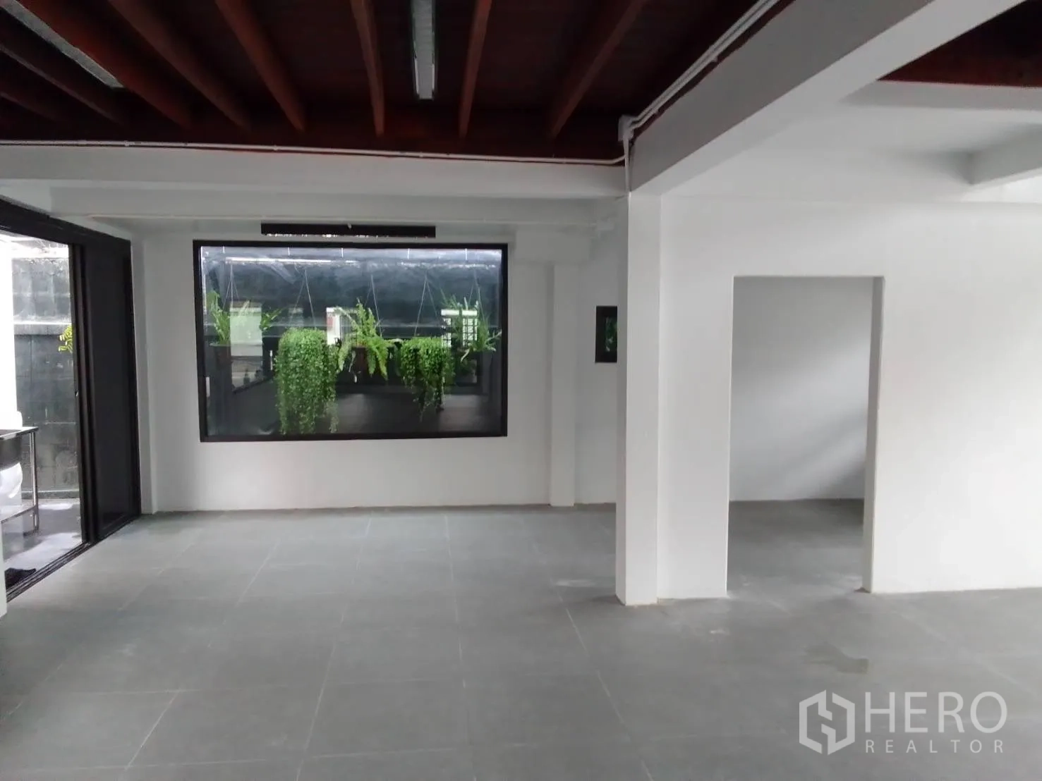 Home Office for rent in Wang Thonglang, Bangkok - Ground floor hall with grey tile floor and a window looking onto green planters