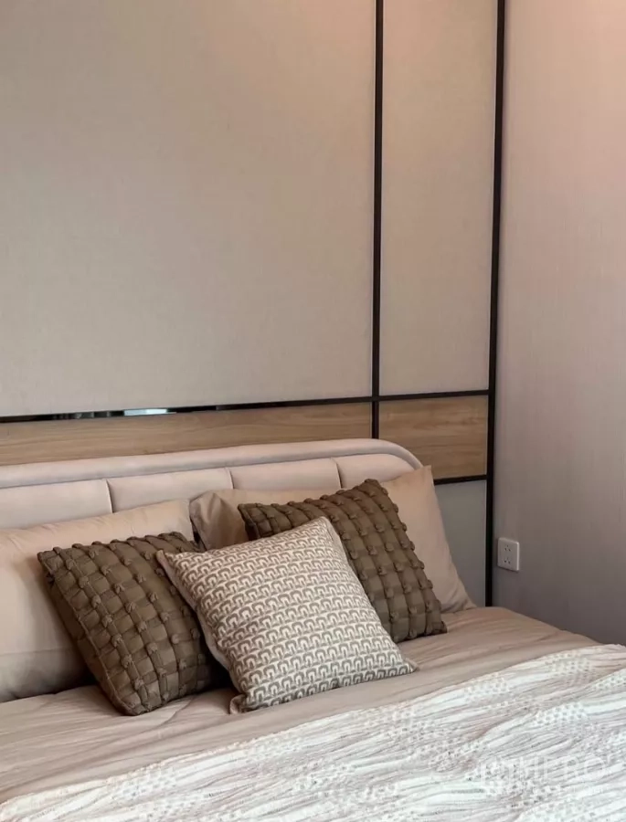 Detached House for rent in Samut Prakan - Bedroom detail showing an upholstered headboard, patterned cushions and a paneled feature wall.