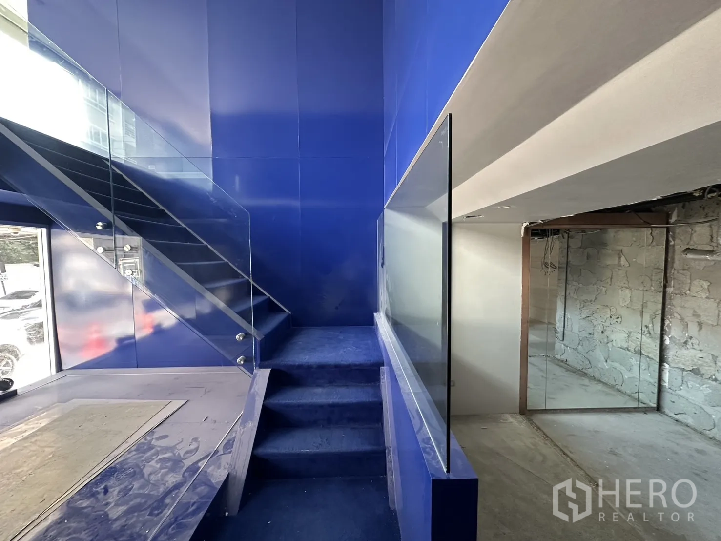 Retail Space for rent in Watthana, Bangkok - Blue feature staircase with a glass balustrade and display platform by the front window.