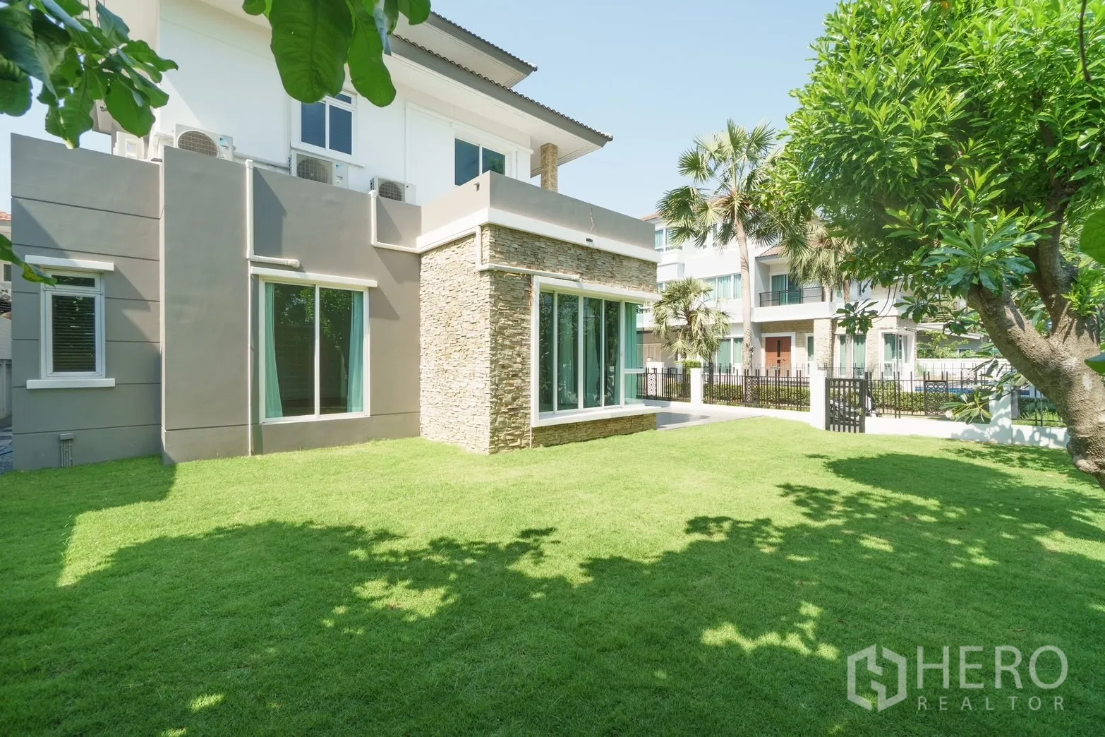Detached House for rent or sale in Saphan Sung, Bangkok - Modern detached house exterior with wide lawn and trees.