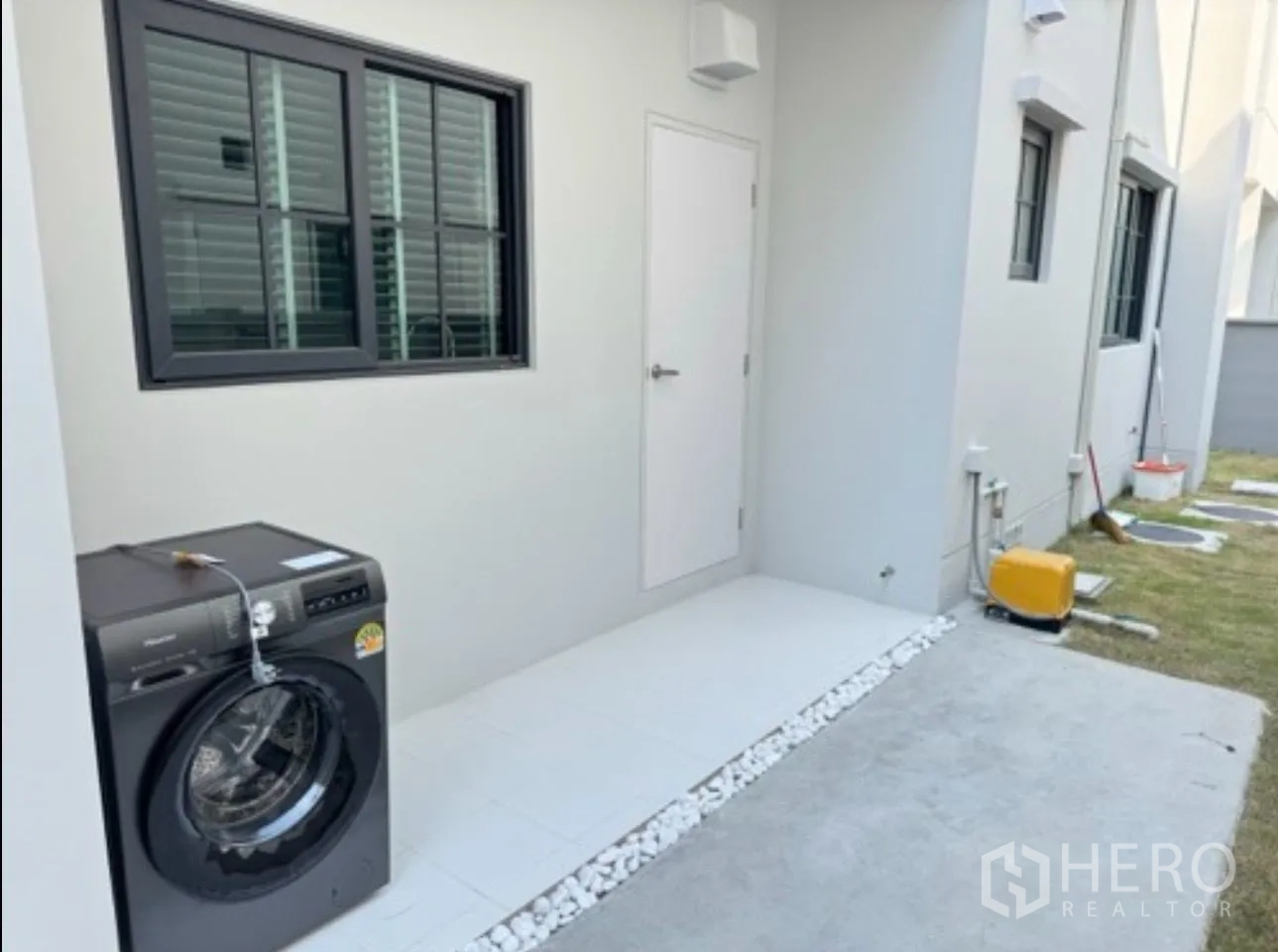 独栋房屋 for rent in Bang Phli, Samut Prakan - 室外家务区配洗衣机、侧边步道与小草坪。