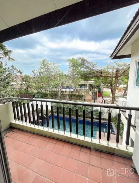Detached House for rent in Bang Phli, Samut Prakan - Second-floor balcony with dark railing overlooking the pool and treetops.