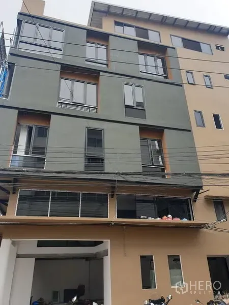 Office Space for rent in Khlong Toei, Bangkok - Modern mid-rise office building exterior in Khlong Toei with multiple windows and street power lines.