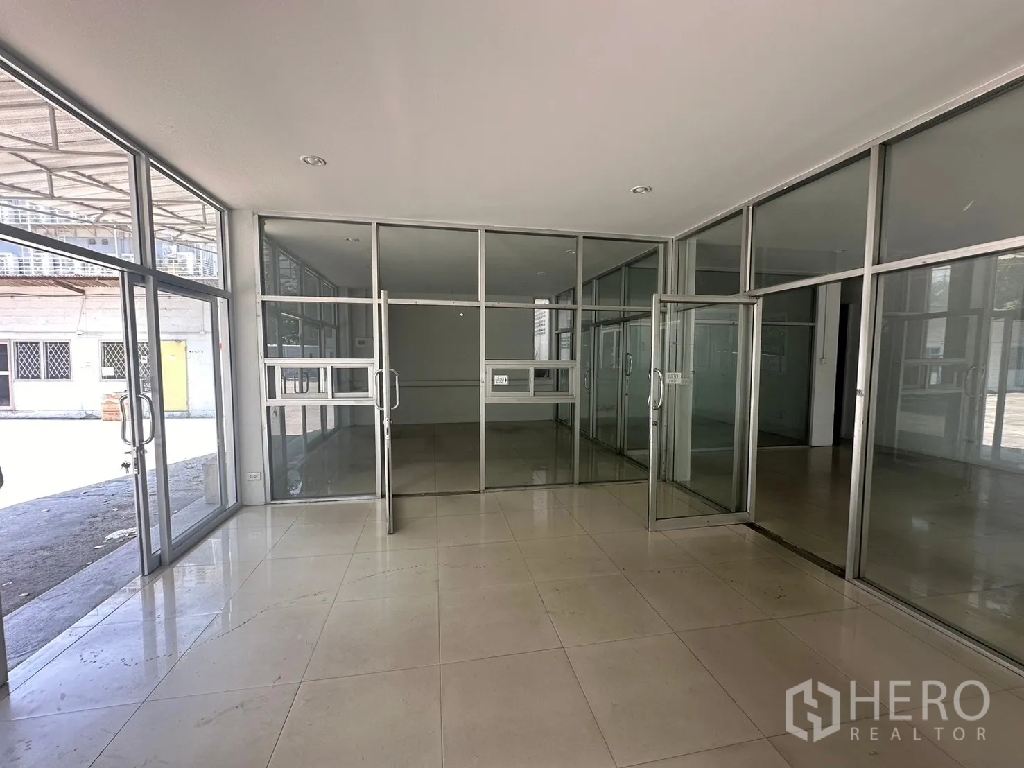 Warehouse for rent in Din Daeng, Bangkok - Glass-partitioned lobby and office zone with tiled flooring and sliding doors.
