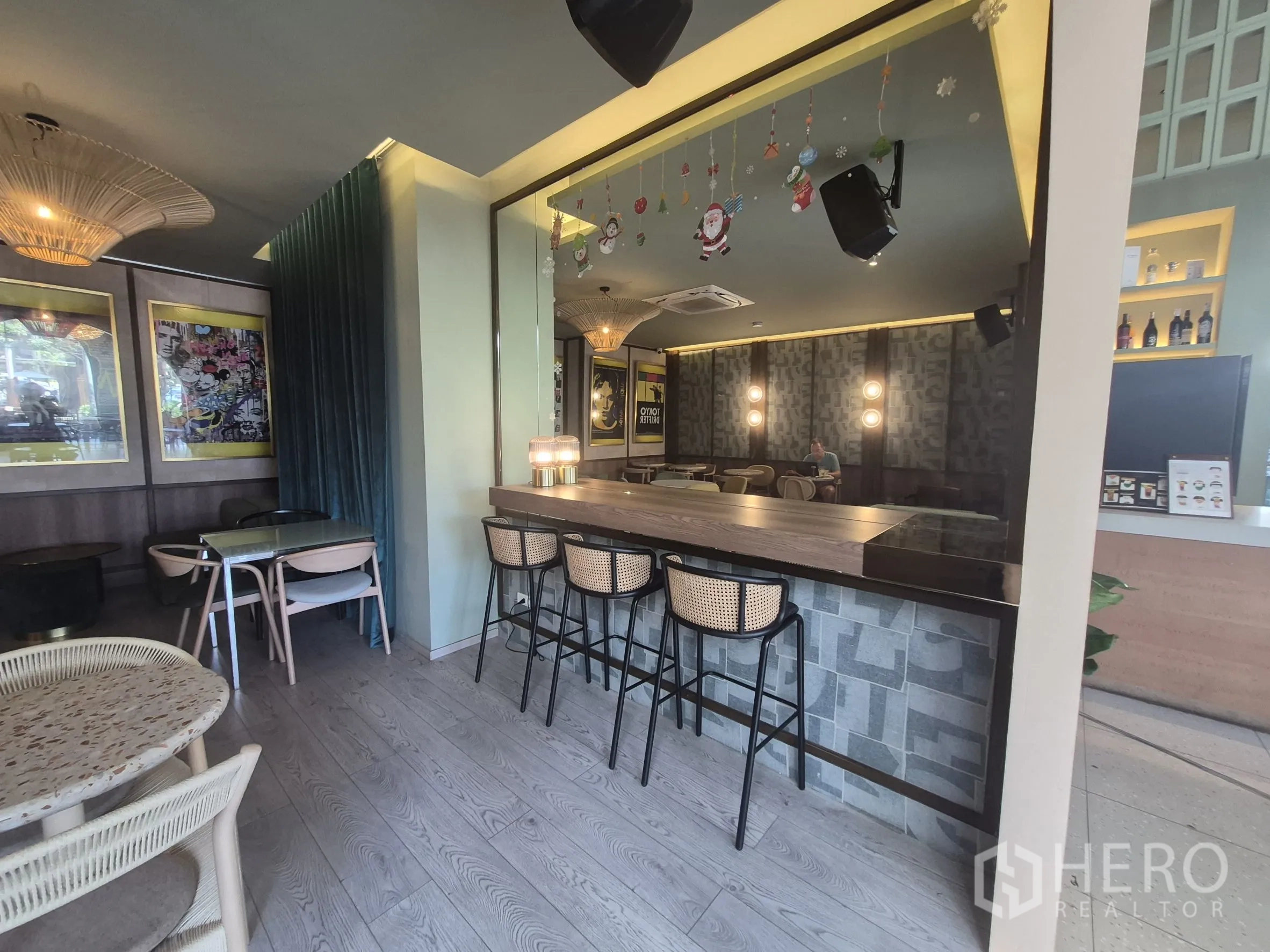 零售空间 for rent in Watthana, Bangkok - 现代室内吧台配高脚椅，旁有用餐桌椅与陈列架。