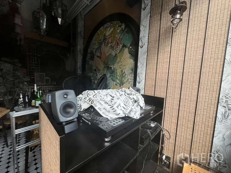 零售空间 出租在Watthana, Bangkok - 室内角落，DJ混音台与音箱，编织质感墙面及热带植物壁画。