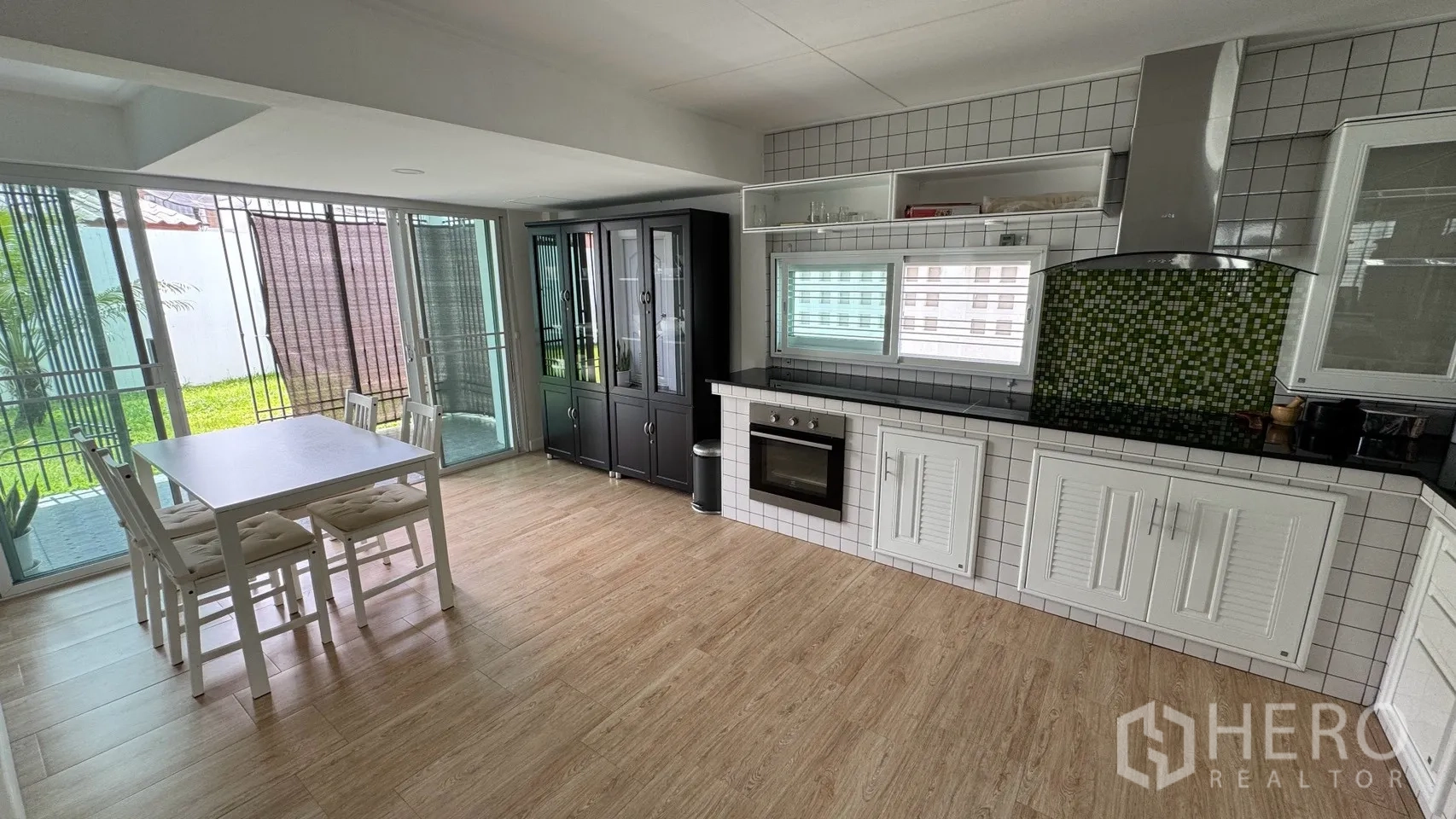 Detached House for rent in Saphan Sung, Bangkok - Dining nook beside sliding glass doors opening to the garden next to the tiled kitchen.