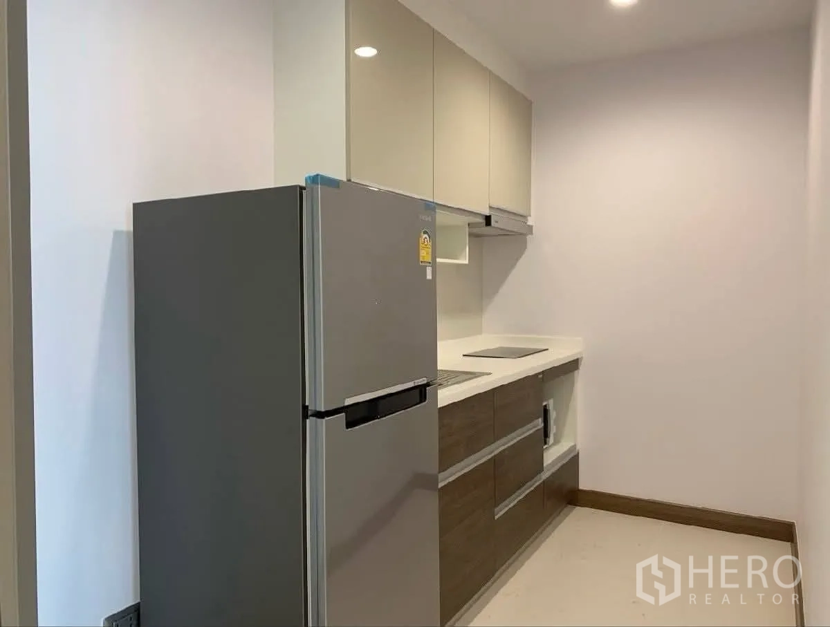 公寓 for rent in Watthana, Bangkok - 紧凑型厨房，配有冰箱、电磁炉和吊柜。