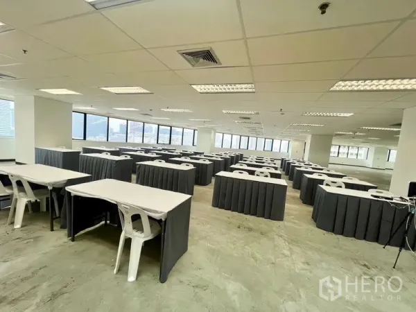 สำนักงาน ให้เช่า - พื้นที่สำนักงานสว่าง จัดวางโต๊ะอบรมและเก้าอี้หลายแถว ข้างหน้าต่างพาโนรามาวิวเมือง.